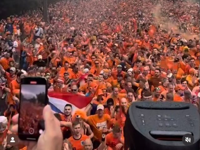Oranjefans vullen de straat, met een PartyBox op de voorgrond