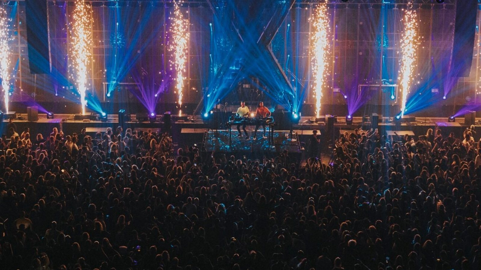 Exposed: podium met vuurwerk, blauw licht en een volle zaal